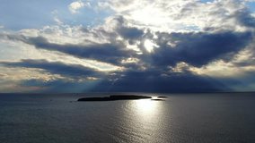 Aerial drone video of sunset over open deep blue ocean and beautiful clouds with golden colours