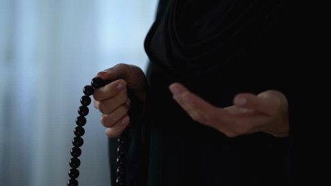 Muslim woman praying with islamic beads in hand, religious meditation, worship