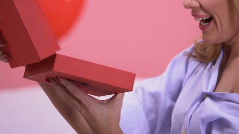 Woman opening gift box with jewelry, long-awaited present for Valentines day