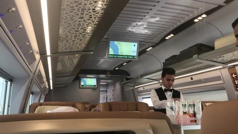 MECCA, SAUDI ARABIA - DEC 2, 2018: Stewards serve the passengers in the  Haramain HSR (Mecca–Medina High-Speed Railway). Serve food and drinks in the passenger business class coach.