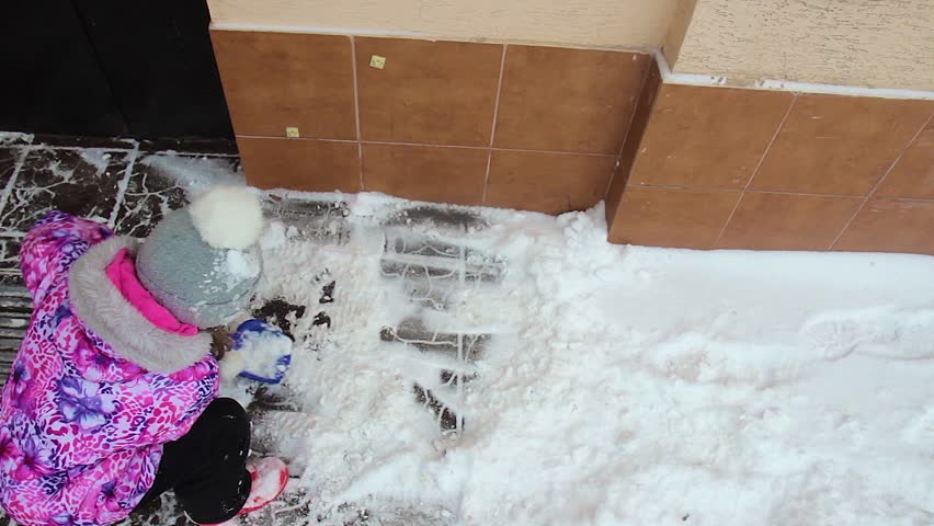 little girl removes the snow outside