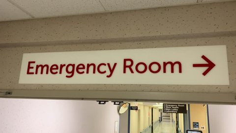 Emergency room sign and hour in hospital hall