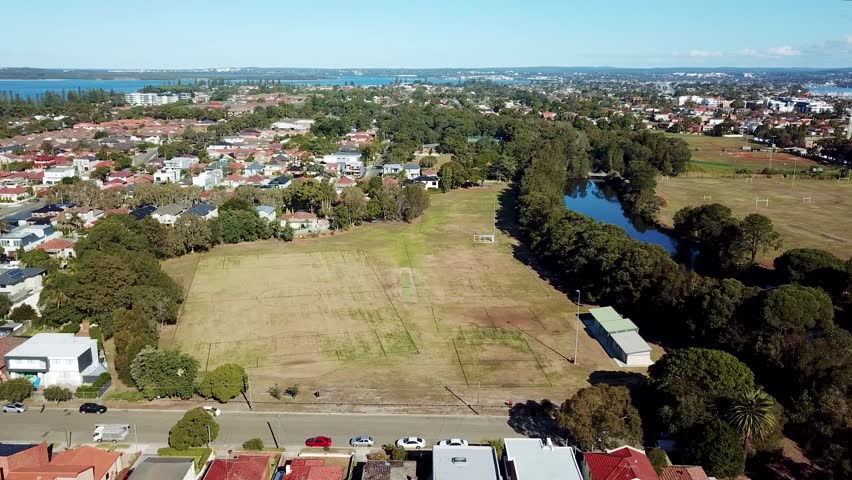 Areal footage moving sideways over the river and park with city and ocean view in the background