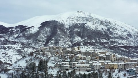 Aerial view of the beautiful snow-covered village of Opi with snow-capped mountains in the background. Opi is a comune and town in the province of L'Aquila in the Abruzzo region of central Italy.