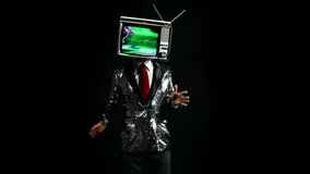 cool male performer with a television as a head. the tv has distortion and static on the screen and the man is dancing