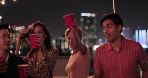 Group of friends dancing at a rooftop party