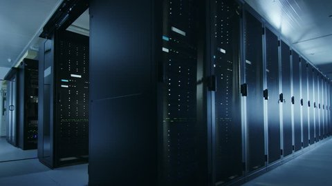 Camera Walkthrough Shot of a Working Data Center With Rows of Rack Servers. Led Lights Blinking and Computers are Working. Room is Dark.