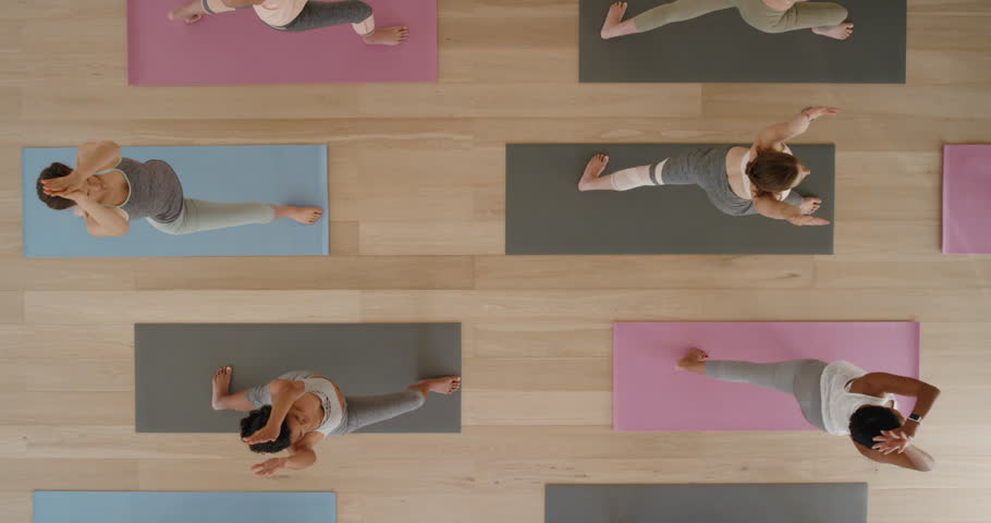 Top view yoga class healthy women practicing warrior pose enjoying fitness lifestyle exercising in gym | Shutterstock HD Video #1021975738