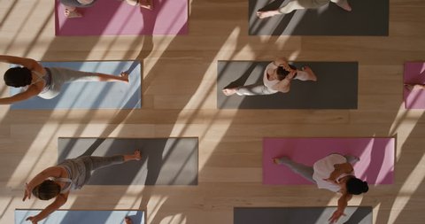 above view yoga class healthy women practicing warrior pose enjoying fitness lifestyle exercising in studio at sunrise