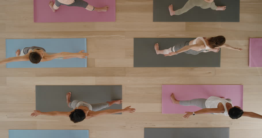 Top view yoga class healthy women practicing cobra pose enjoying fitness lifestyle exercising in gym | Shutterstock HD Video #1021975759