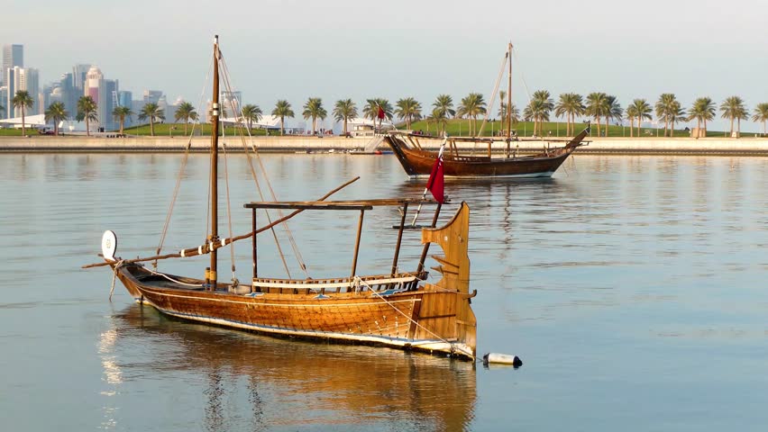 A panoramic view of the old dhow harbour timelapse in Doha, Qatar, Middle East. Day Shot. Traditional Wooden Qatar Boats at Corniche Broadway Coast in Clean Azure Water of Persian Gulf.