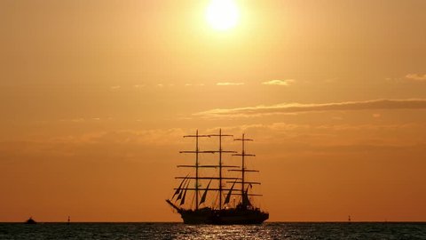 during sunset Beautiful silhouette sailing vessel in the sea. three-masted ship floats on the high seas