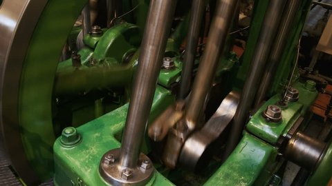 Close-up shot of a flywheel of a single cylinder industrial steam engine in operation