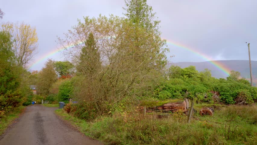 A Rainbow, seen after raining, on a trekking pathway around Loch Achray, in Scotland. The rainbow is fully colored and all the colors in the spectrum are visible.