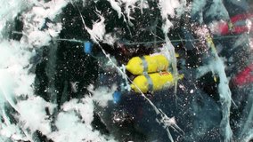 Technical diver under frozen ice hole underwater of lake Baikal as concept of extreme sports and active lifestyle.