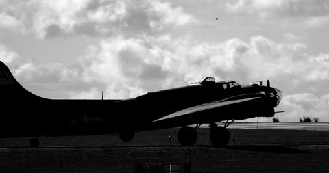 WWII B17 airplane turning on runway - silhouetted in black and white