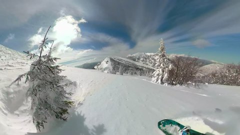 POV, 360 VR: Speeding downhill while snowboarding in the picturesque Slovenian Alps. Breathtaking shot of shredding the fresh powder snow covering the ungroomed slopes in idyllic sunny mountains.