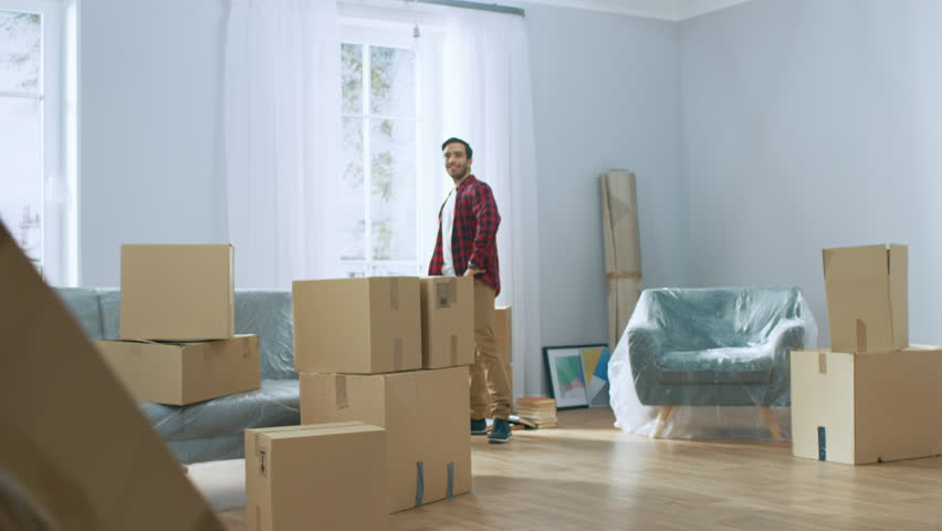 Happy New Homeowner Welcomes Professional Mover with Hand Truck full of Cardboard Boxes, Receives His Goods and Signs on Clipboard. Royalty-Free Stock Footage #1022013613