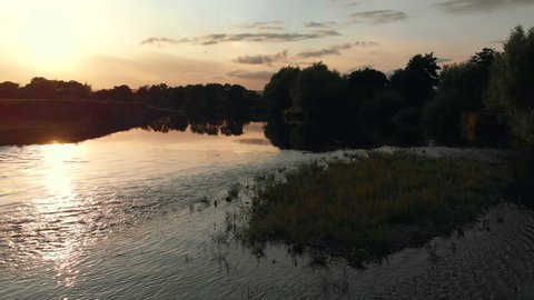 Slow low aerial camera footage rising up over the river wye at sunset in summer