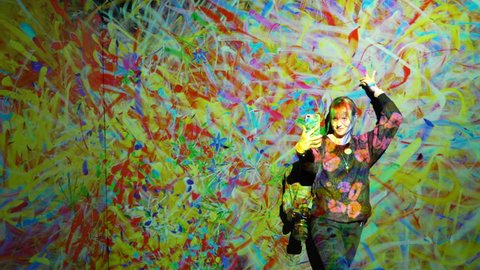 HELSINKI, FINLAND - JAN 06, 2019: "Massless" Exhibition - immersive interactive graphic digital installations by Japanese artists TeamLab at Amos Rex Museum.Woman taking selfies wih new modern art