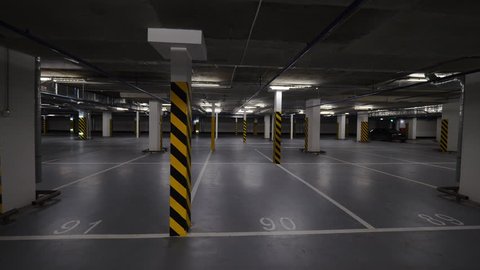 Rotating shot of almost empty underground parking garage with just two cars there