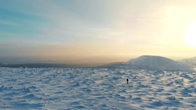 Traveler in mountains aerial landscape. Epic drone video of man walking snow mountain landscape. Mountaineer hiking in winter. Travel lifestyle adventure concept winter vacations outdoor aerial view.