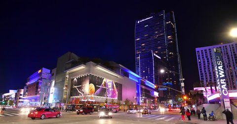 LOS ANGELES, CALIFORNIA - DECEMBER 9, 2018:  Night traffic and people walking near the Grammy Museum, ESPN Zone, L.A. Live, Microsoft Center and Ritz Carlton Hotel in Los Angeles, California, USA, 4K