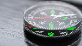 Close up footage of a small magnetic compass by the window. Panning to the left. Selective focus.