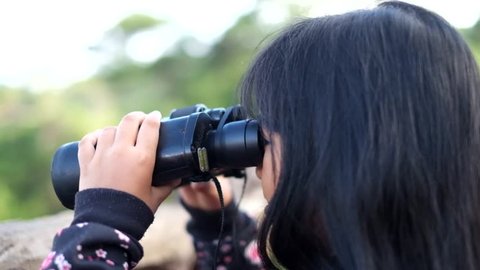Child looking through binoculars on a mountain in Baguio, Philippines
