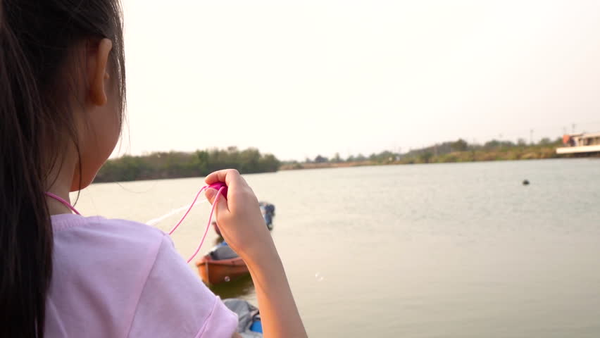Slow Motion: Asian little girl blowing soap bubbles
