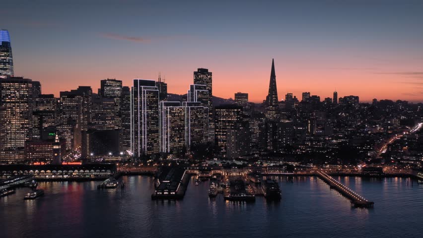 Aerial Drone Of The San Francisco City Skyline, Ferry Terminal and ferries at night.