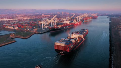 Aerial Of Container Ship sailing into the The Port Of Oakland at sunset, California, USA.