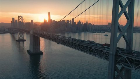 Aerial: The San Francisco City Skyline And Bay Bridge at Sunset.