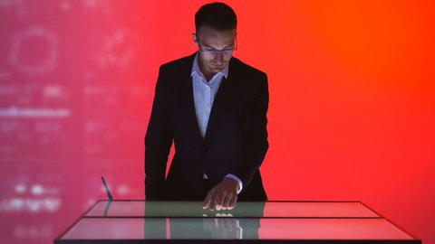 The male working with a touchscreen on the hologram background
