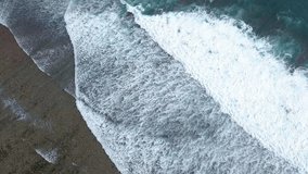 Aerial Top View: Big Ocean Waves Splashing and Making White Foam. 4K Background. Uluwatu, Indonesia, Bali.