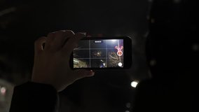 A woman shoots fireworks on a smartphone. Making video by smart phone of Beautiful firework display for celebration.