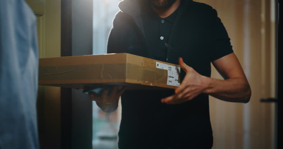 Happy young woman receiving and signing a parcel from mailman  delivered in her home. Shot with RED camera i 8K. Concept of courier, delivery, e-commerce, online shopping Royalty-Free Stock Footage #1022079655