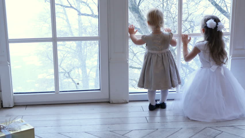 Children looking at window, two little girls looking through window