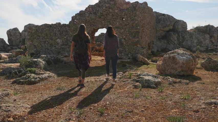 Two young girls exploring ancient city Lyrboton, Turkey