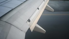 Airplane wing detail during a commercial flight on a sunny day
