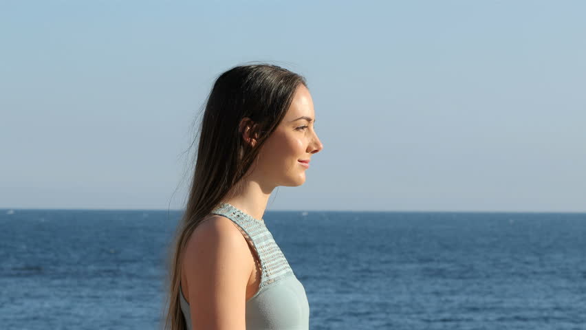 Side view portrait of a happy woman relaxing breathing fresh air on the beach Royalty-Free Stock Footage #1022093020