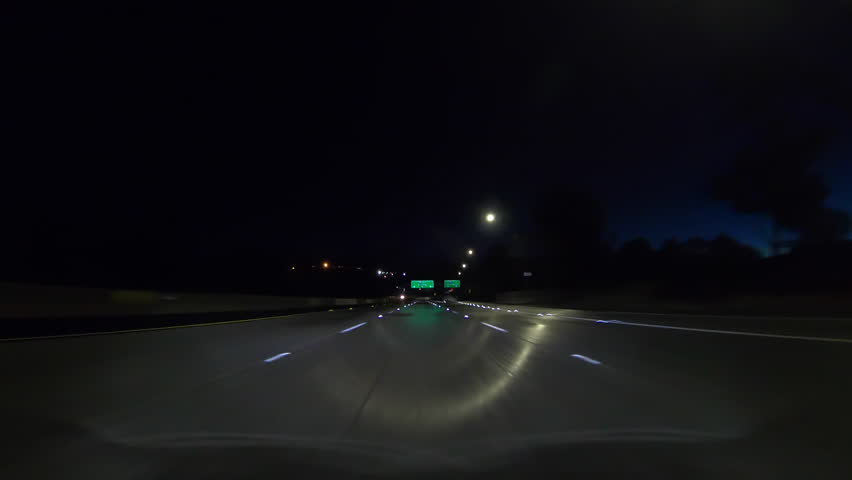 Los Angeles wet freeway dawn driving below route Pasadena 210 signs on route 118 in the San Fernando Valley. 