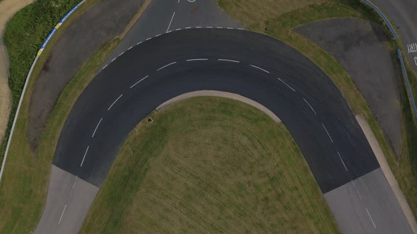 Yellow sports car drifts around corner on racetrack