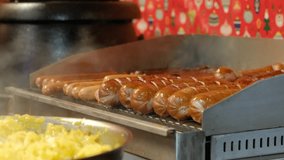 Sausages of a different type are roasted on the electric stove. Sausages fried in a frying pan grill. 4K video.