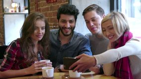 Happy Friends Making Video Call With Mobile Phone In Cafe