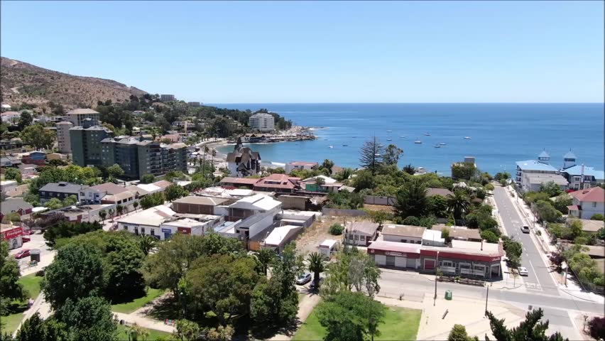 Aerial view of a city, beach and mountain landscape