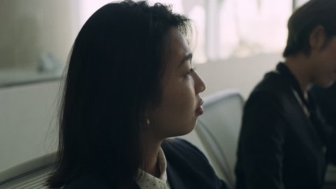 Medium shot on 4k RED camera. Group of Japanese business people work together in a meeting at a large conference room table in a modern office.
