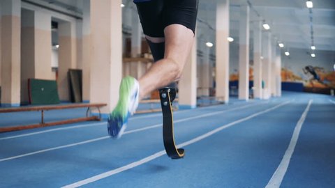 Disabled runner with bionic prosthesis, back view.