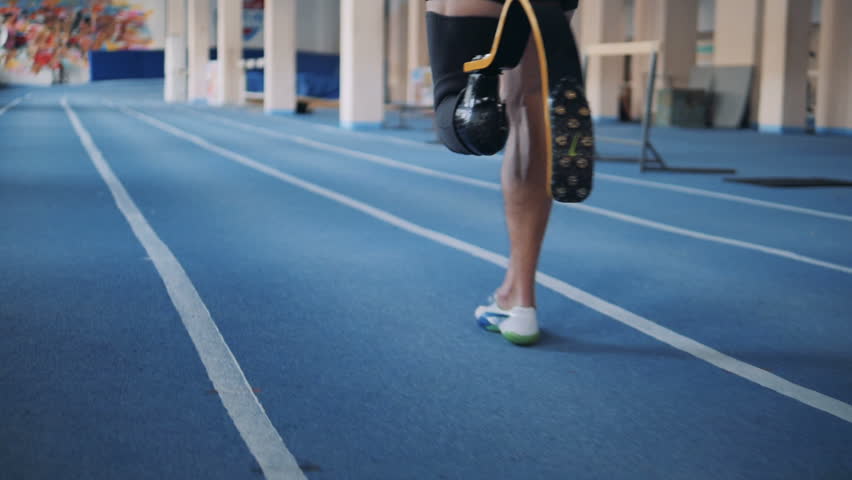 One man with bionic leg training on a running track, back view. Royalty-Free Stock Footage #1022129989