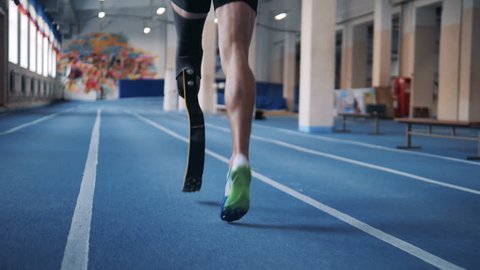 A runner training with prosthetic leg, back view.